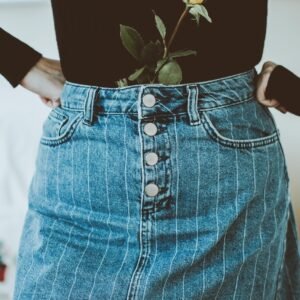 Stylish denim skirt paired with a vibrant rose accent for a unique fashion statement.